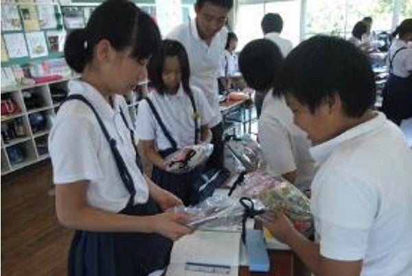 文房具セットを手に取る益城町の生徒たち